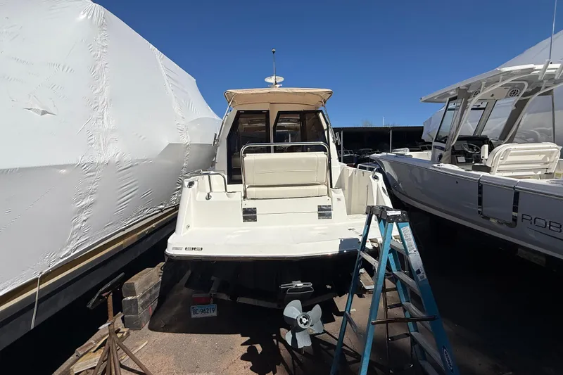 Slide: The Image of 2016 Cutwater 24 boat in storage, surrounded by other boats, with a ladder nearby. - 6