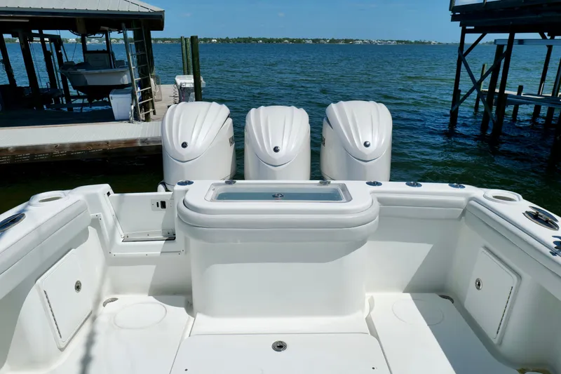 Slide: The Image of 2018 Yellowfin 36 Offshore boat with triple outboard engines docked by the water. - 11