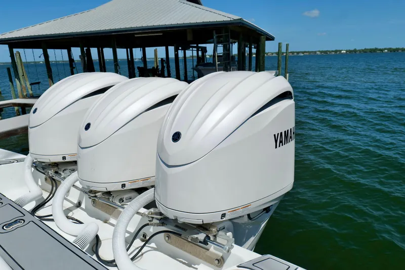 Slide: The Image of Triple Yamaha outboard engines on a 2018 Yellowfin 36 Offshore boat by the dock. - 12