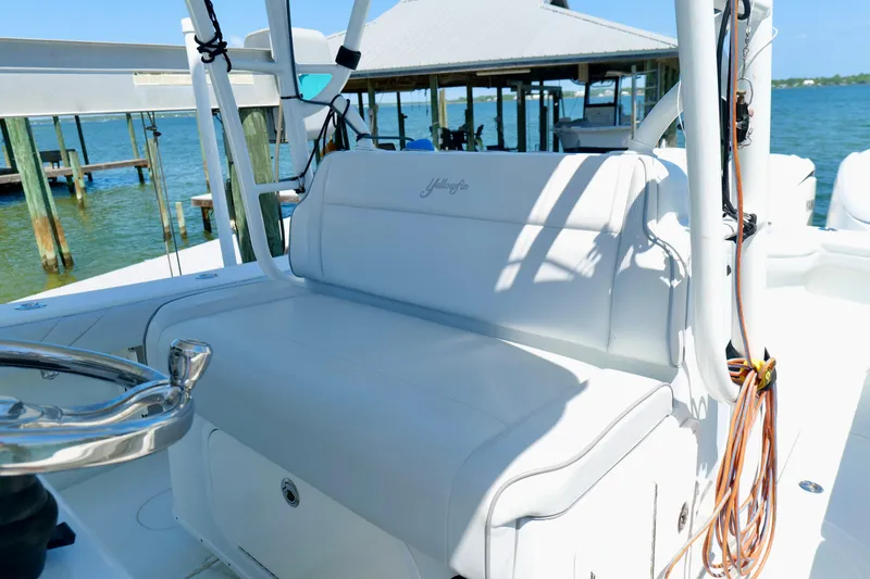 Slide: The Image of 2018 Yellowfin 36 Offshore boat interior with white seating, docked by the water. - 21