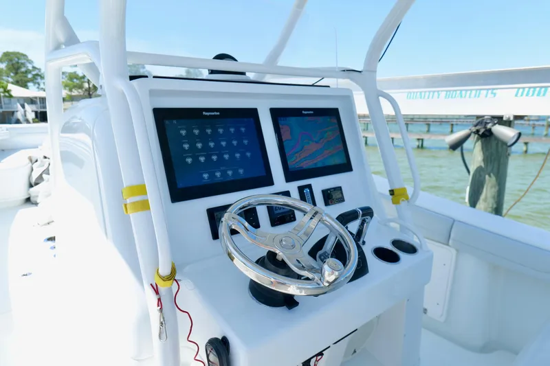 Slide: The Image of 2018 Yellowfin 36 Offshore boat dashboard with dual screens and steering wheel. - 22