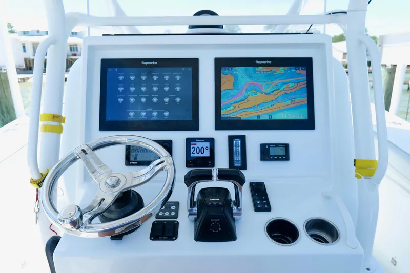 Slide: The Image of Control panel of a 2018 Yellowfin 36 Offshore boat with navigation screens and steering wheel. - 23