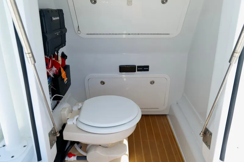 Slide: The Image of 2018 Yellowfin 36 Offshore boat interior with marine toilet and control panel. - 29