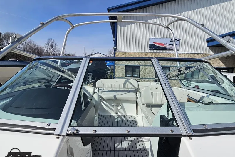 Slide: The Image of 2008 Regal 2520 FasDeck boat with open cockpit and sleek design, parked outdoors. - 102