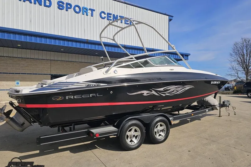 Slide: The Image of 2008 Regal 2520 FasDeck boat on trailer outside a sports center. - 11