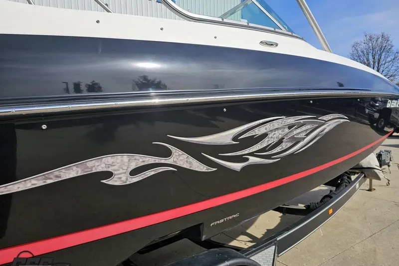 Slide: The Image of 2008 Regal 2520 FasDeck boat with sleek black hull and decorative silver graphics. - 13