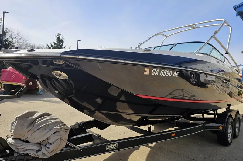 Slide: The Image of 2008 Regal 2520 FasDeck boat on trailer, sleek black design, parked outdoors. - 23