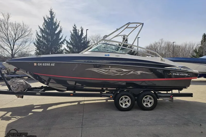 Slide: The Image of 2008 Regal 2520 FasDeck boat on trailer, parked outdoors with trees in background. - 25