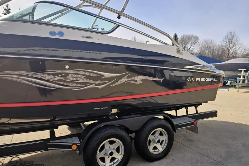 Slide: The Image of 2008 Regal 2520 FasDeck boat on trailer, featuring sleek design and decorative graphics. - 27