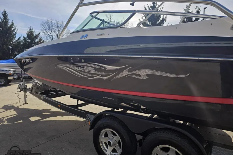 Slide: The Image of 2008 Regal 2520 FasDeck boat on trailer, featuring sleek design and decorative graphics. - 30