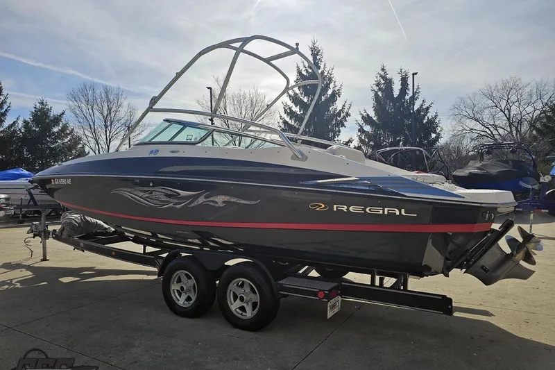 Slide: The Image of 2008 Regal 2520 FasDeck boat on trailer, parked outdoors under clear sky. - 32