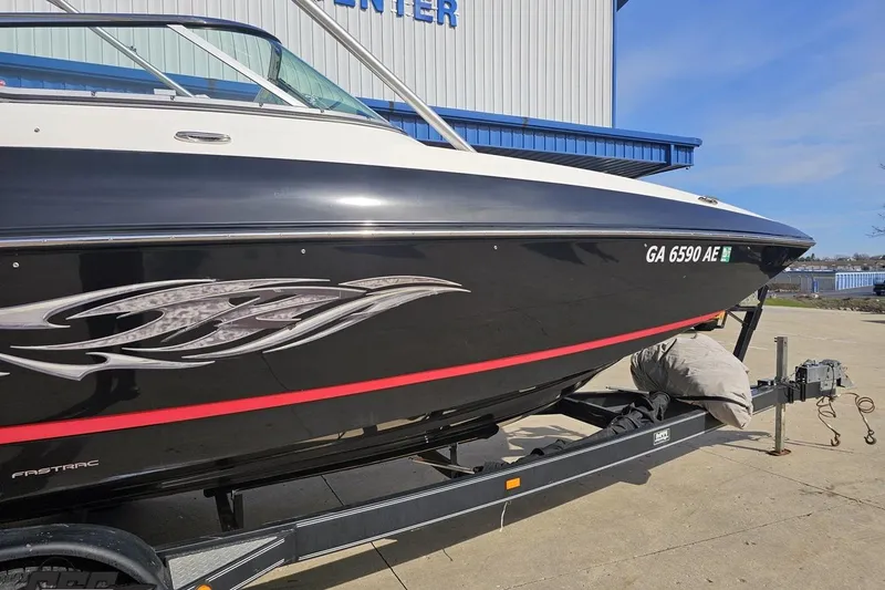 Slide: The Image of 2008 Regal 2520 FasDeck boat on trailer, black with red stripe, parked outdoors. - 6