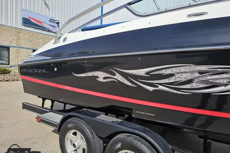 Slide: The Image of 2008 Regal 2520 FasDeck boat with sleek black design and decorative graphics. - 7