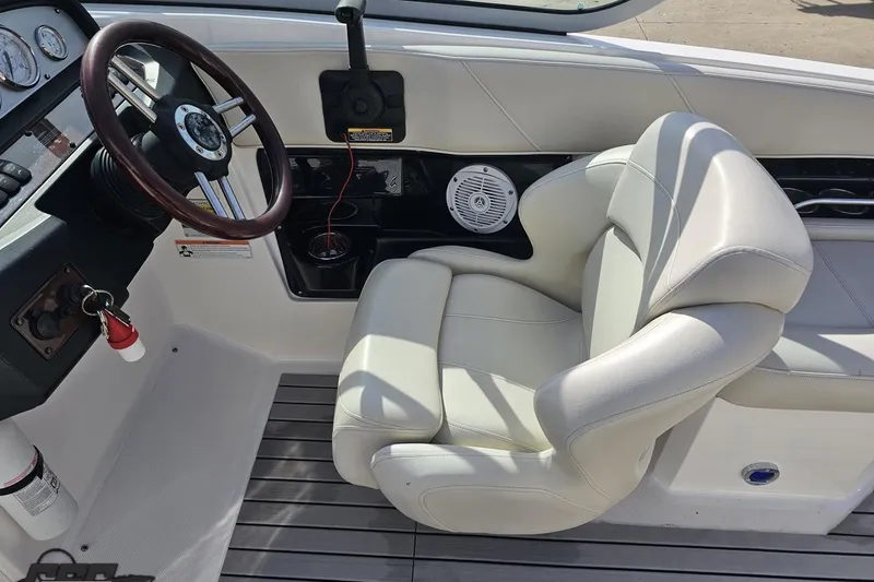 Slide: The Image of Steering area of a 2008 Regal 2520 FasDeck boat with white seating and dashboard controls. - 73