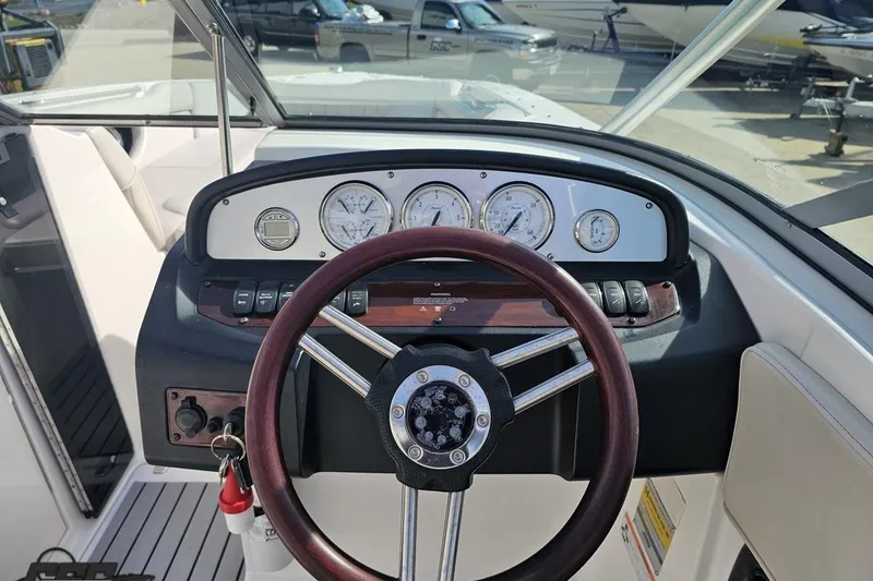 Slide: The Image of Cockpit view of a 2008 Regal 2520 FasDeck boat with steering wheel and gauges. - 77