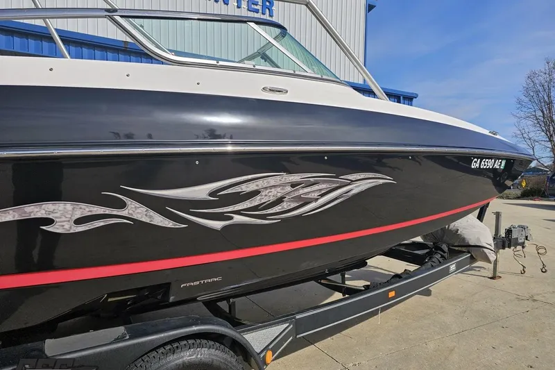 Slide: The Image of 2008 Regal 2520 FasDeck boat with sleek black design and decorative graphics. - 8