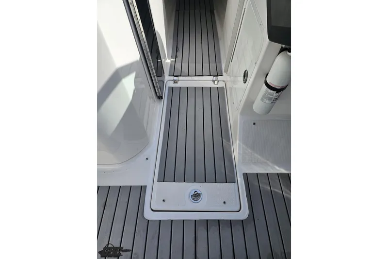 Slide: The Image of 2008 Regal 2520 FasDeck boat interior with gray flooring and fire extinguisher. - 80