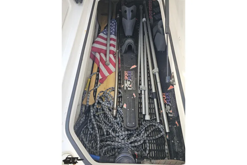 Slide: The Image of Storage compartment of a 2008 Regal 2520 FasDeck with water sports equipment and an American flag. - 81