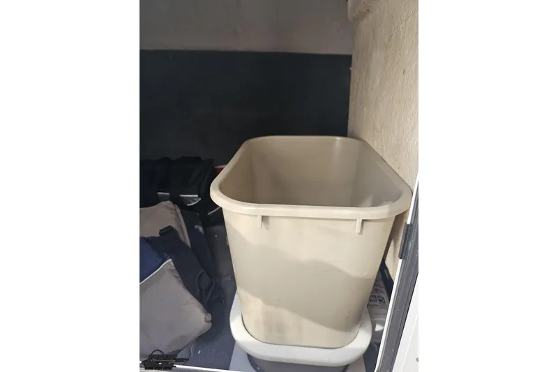 Slide: The Image of Storage compartment of a 2008 Regal 2520 FasDeck boat with a beige bin. - 83