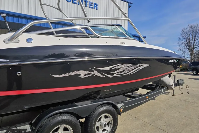 Slide: The Image of 2008 Regal 2520 FasDeck boat on trailer, black with red stripe, parked outdoors. - 9