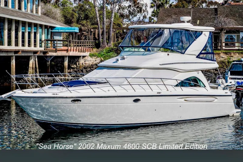 The Image of 2002 Maxum 4600 SCB Limited Edition yacht docked near waterfront buildings. - 1