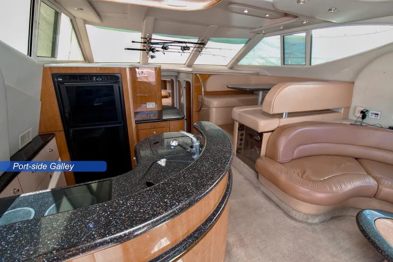 Slide: The Image of Luxurious interior of 2002 Maxum 4600 SCB yacht with elegant port-side galley and seating area. - 14
