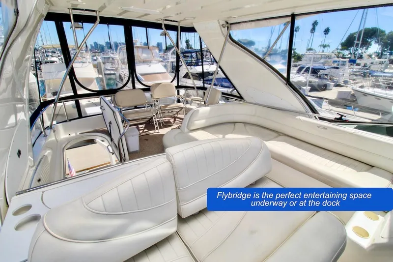 Slide: The Image of Flybridge of 2002 Maxum 4600 SCB yacht, featuring spacious seating and marina view. - 9