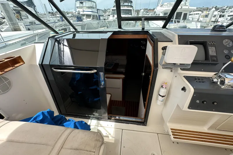 Slide: The Image of 1990 Tiara Yachts 3600 Open cockpit with helm, cabin entrance, and marina view. - 10