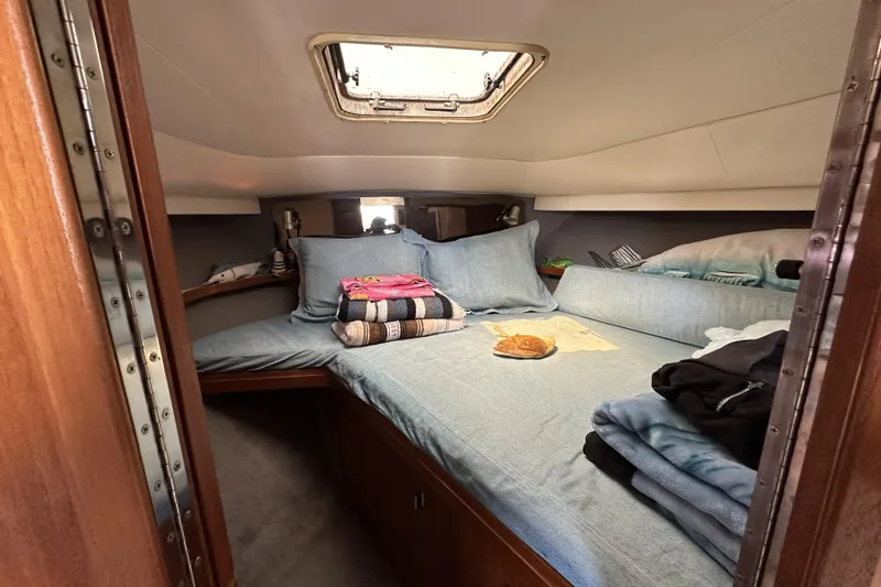 Slide: The Image of Cozy cabin interior of 1990 Tiara Yachts 3600 Open with bedding and skylight. - 13
