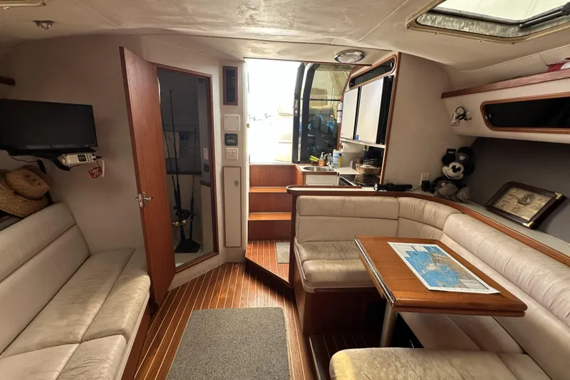 Slide: The Image of Interior of 1990 Tiara Yachts 3600 Open, featuring cozy seating and a wooden table. - 14