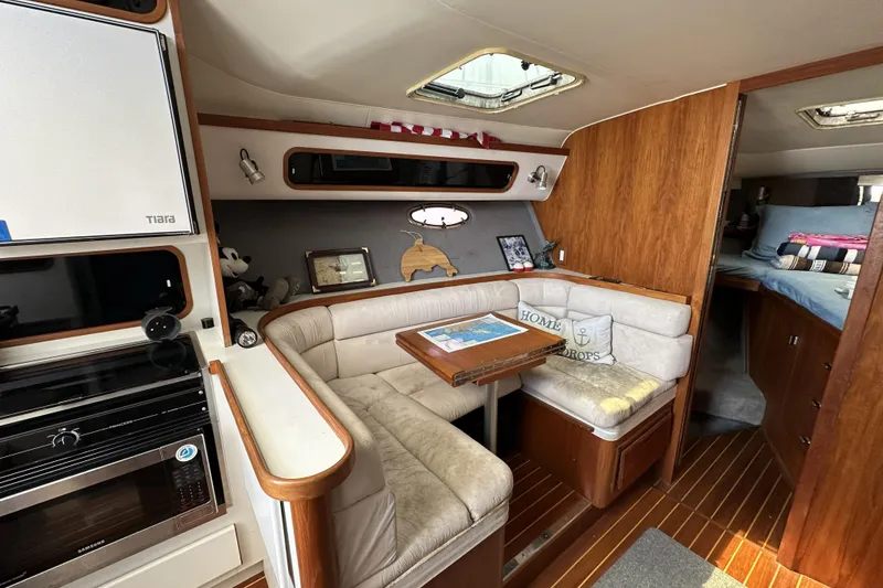 Slide: The Image of Interior of 1990 Tiara Yachts 3600 Open, featuring cozy seating and wooden accents. - 15