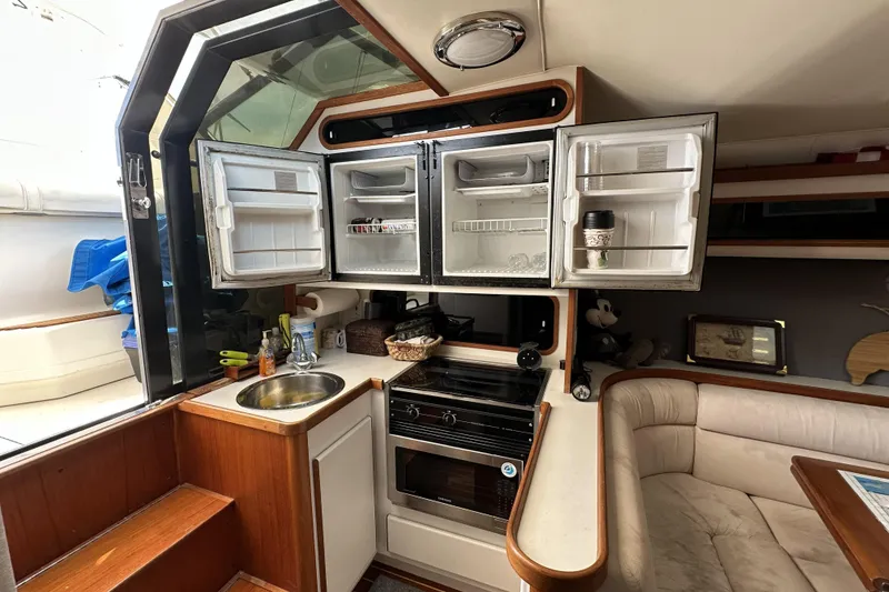 Slide: The Image of Interior of a 1990 Tiara Yachts 3600 Open, featuring a compact kitchen area. - 18