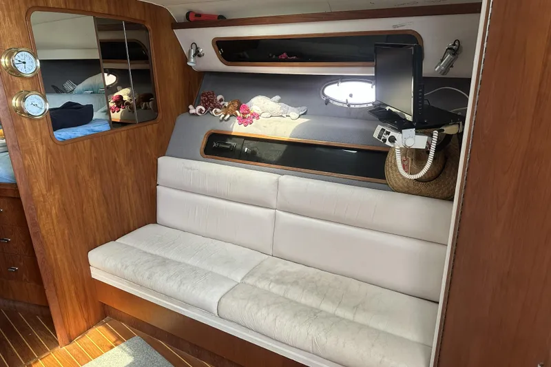 Slide: The Image of Interior of 1990 Tiara Yachts 3600 Open with white seating and wooden accents. - 19