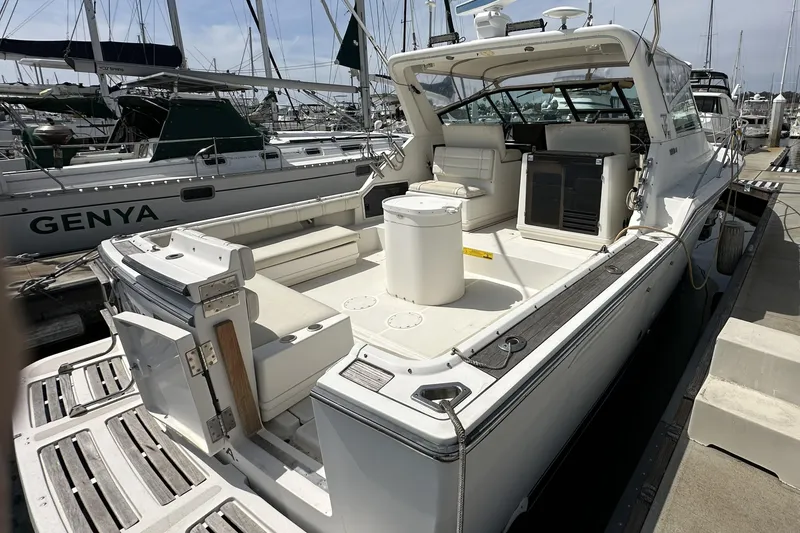 Slide: The Image of 1990 Tiara Yachts 3600 Open docked, showcasing spacious deck and seating area. - 3