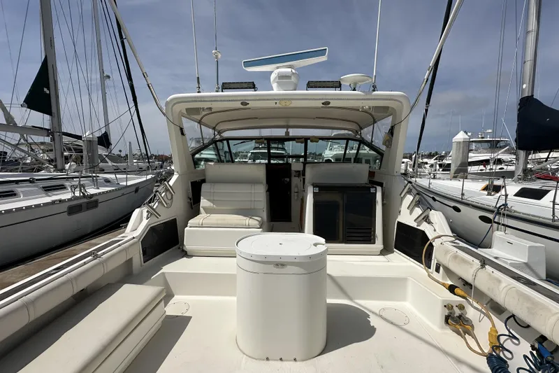Slide: The Image of 1990 Tiara Yachts 3600 Open docked, showcasing spacious deck and seating area. - 6
