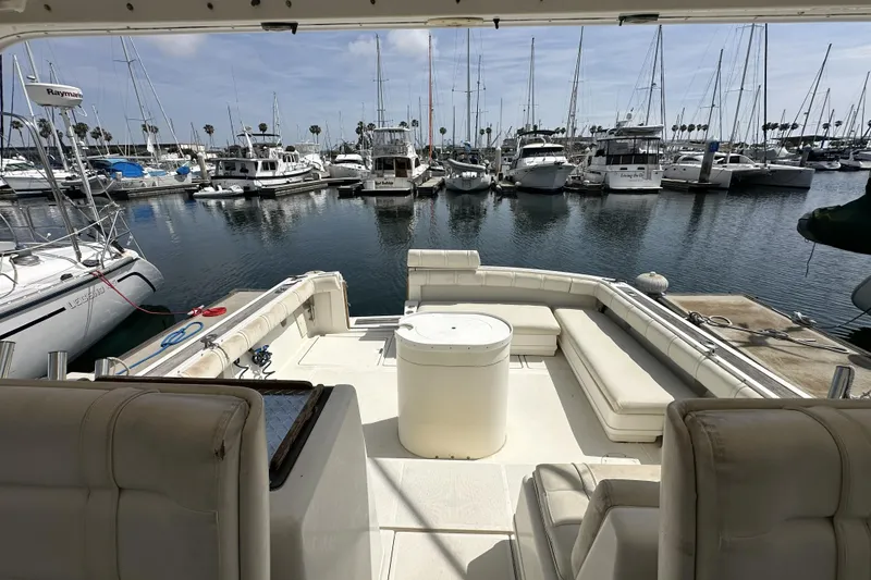 Slide: The Image of 1990 Tiara Yachts 3600 Open at marina, featuring spacious deck and seating area. - 8