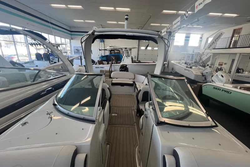 Slide: The Image of 2024 Crownline Eclipse E290 XS boat interior in showroom, featuring sleek design and spacious seating. - 18