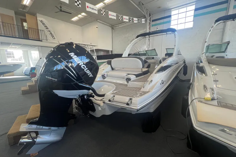 Slide: The Image of 2024 Crownline Eclipse E290 XS boat with Mercury Verado engine in showroom. - 2