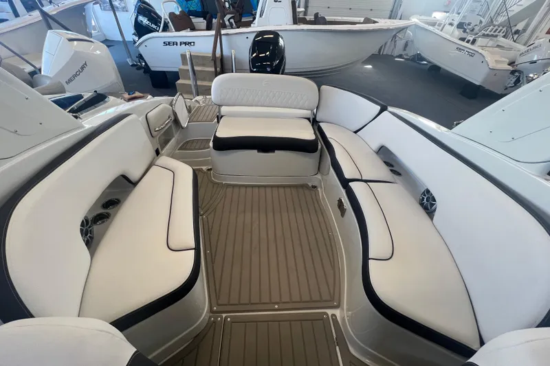 Slide: The Image of 2024 Crownline Eclipse E290 XS boat interior with white seating and wood flooring. - 3
