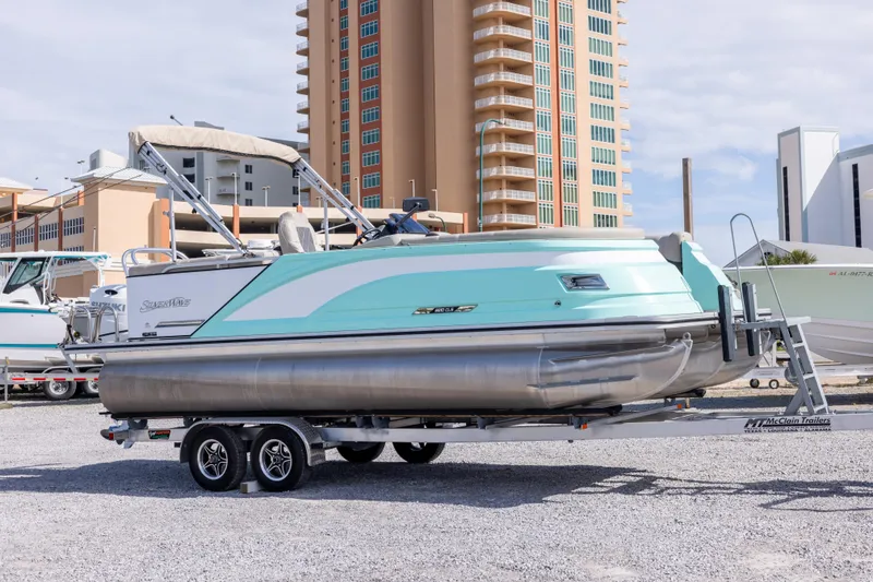 The Image of 2024 SilverWave 2210 CLS SW5 pontoon boat on trailer, urban background. - 0