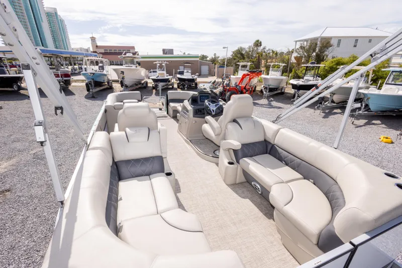 Slide: The Image of 2024 SilverWave 2210 CLS SW5 pontoon boat interior with luxurious seating, docked near other boats. - 13