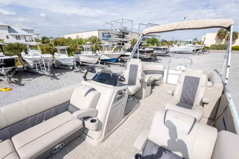 Slide: The Image of 2024 SilverWave 2210 CLS SW5 pontoon boat with luxurious seating and canopy in a marina setting. - 22