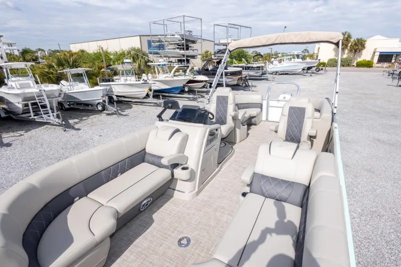 Slide: The Image of 2024 SilverWave 2210 CLS SW5 pontoon boat with luxurious seating and modern design at a marina. - 24