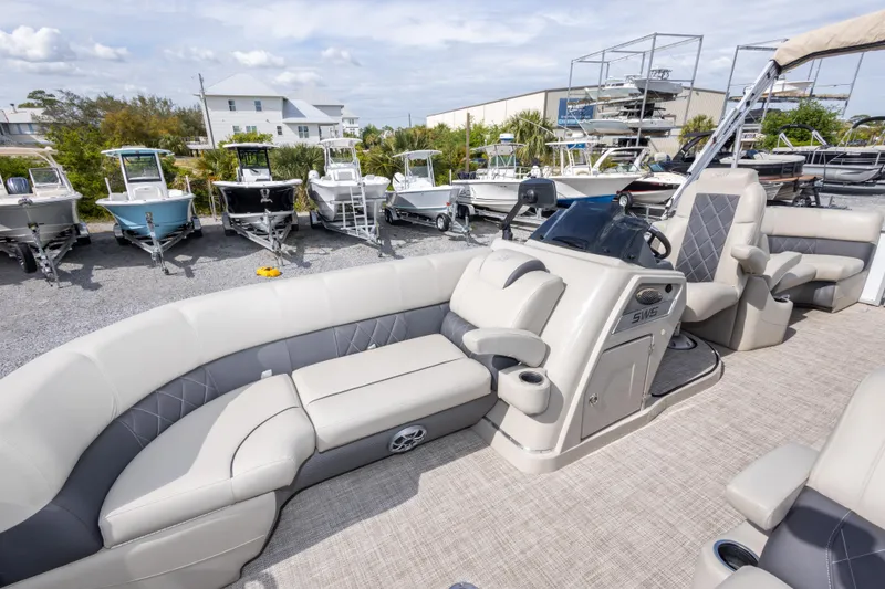 Slide: The Image of 2024 SilverWave 2210 CLS SW5 pontoon boat with luxurious seating in a marina setting. - 26