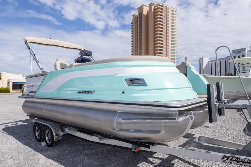 Slide: The Image of 2024 SilverWave 2210 CLS SW5 pontoon boat on trailer, with cityscape background. - 3