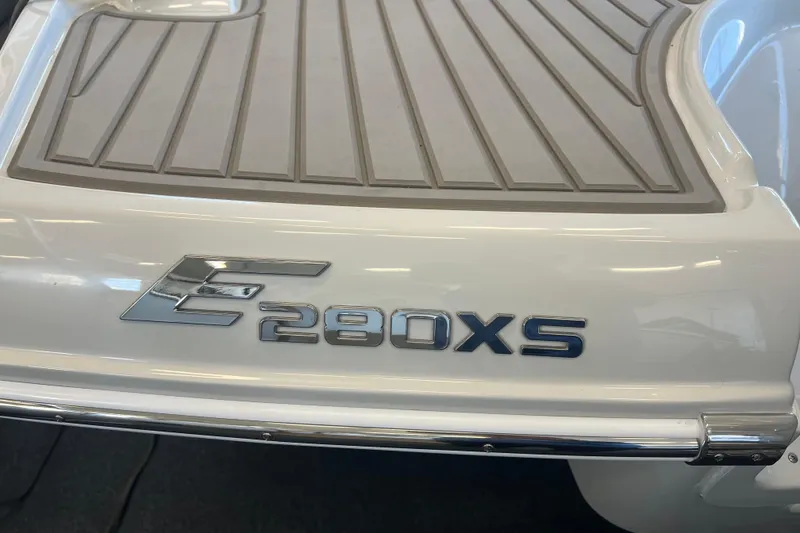 Slide: The Image of 2024 Crownline Eclipse E280 XS boat emblem on a sleek white surface. - 20