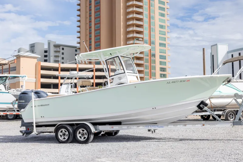 The Image of 2019 Sportsman Heritage 251 Center Console boat on trailer, urban background. - 0