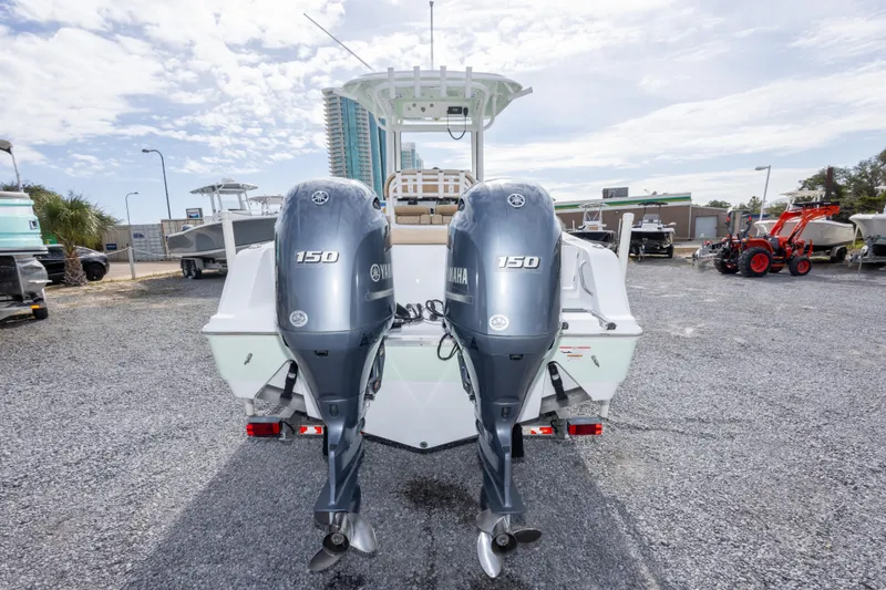 Slide: The Image of 2019 Sportsman Heritage 251 Center Console with twin Yamaha 150 engines, parked on gravel. - 15