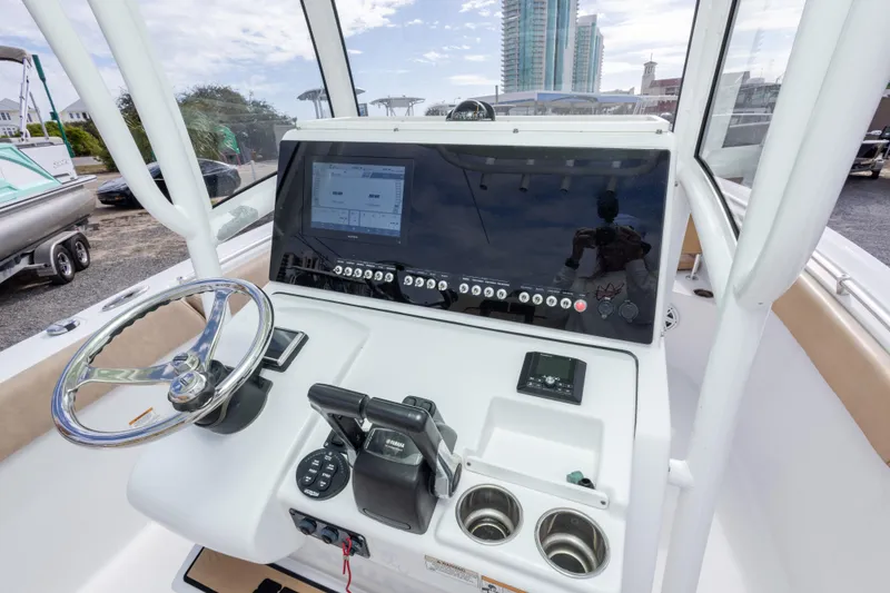 Slide: The Image of 2019 Sportsman Heritage 251 Center Console boat dashboard with steering wheel and controls. - 21