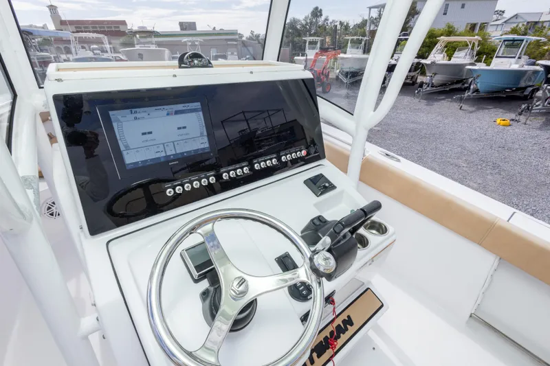 Slide: The Image of 2019 Sportsman Heritage 251 Center Console boat dashboard with steering wheel and navigation display. - 23